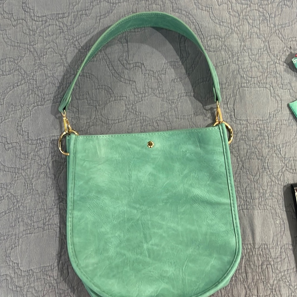 Ah-dorned turquoise purse with shorter strap